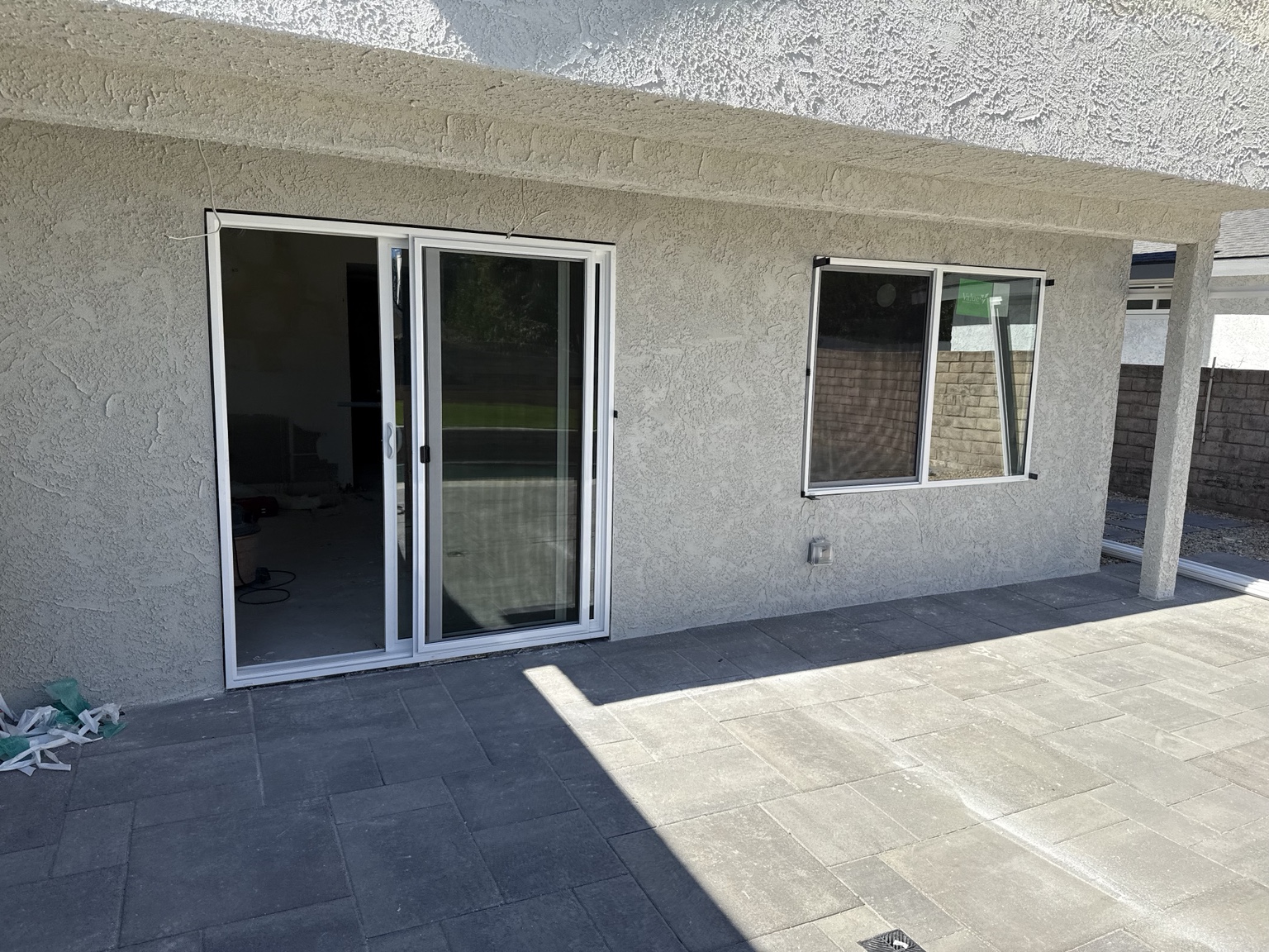 Exterior renovation with replacement windows, sliding door and patio pavers