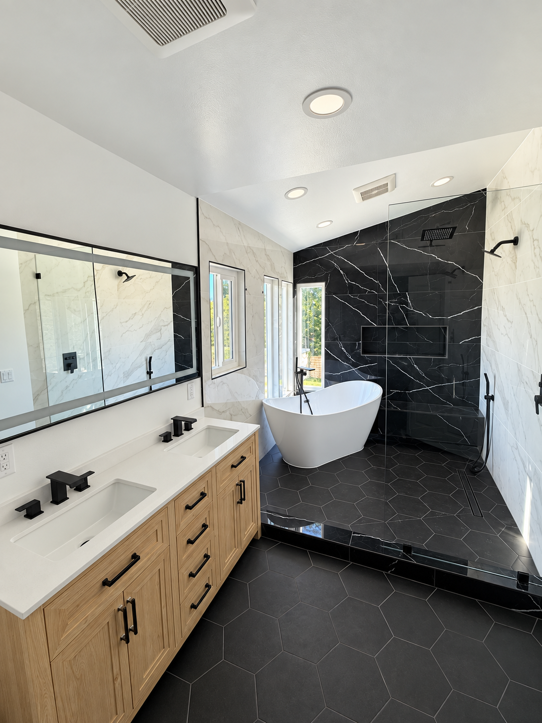 Primary bathroom with freestanding tub and stone finishes